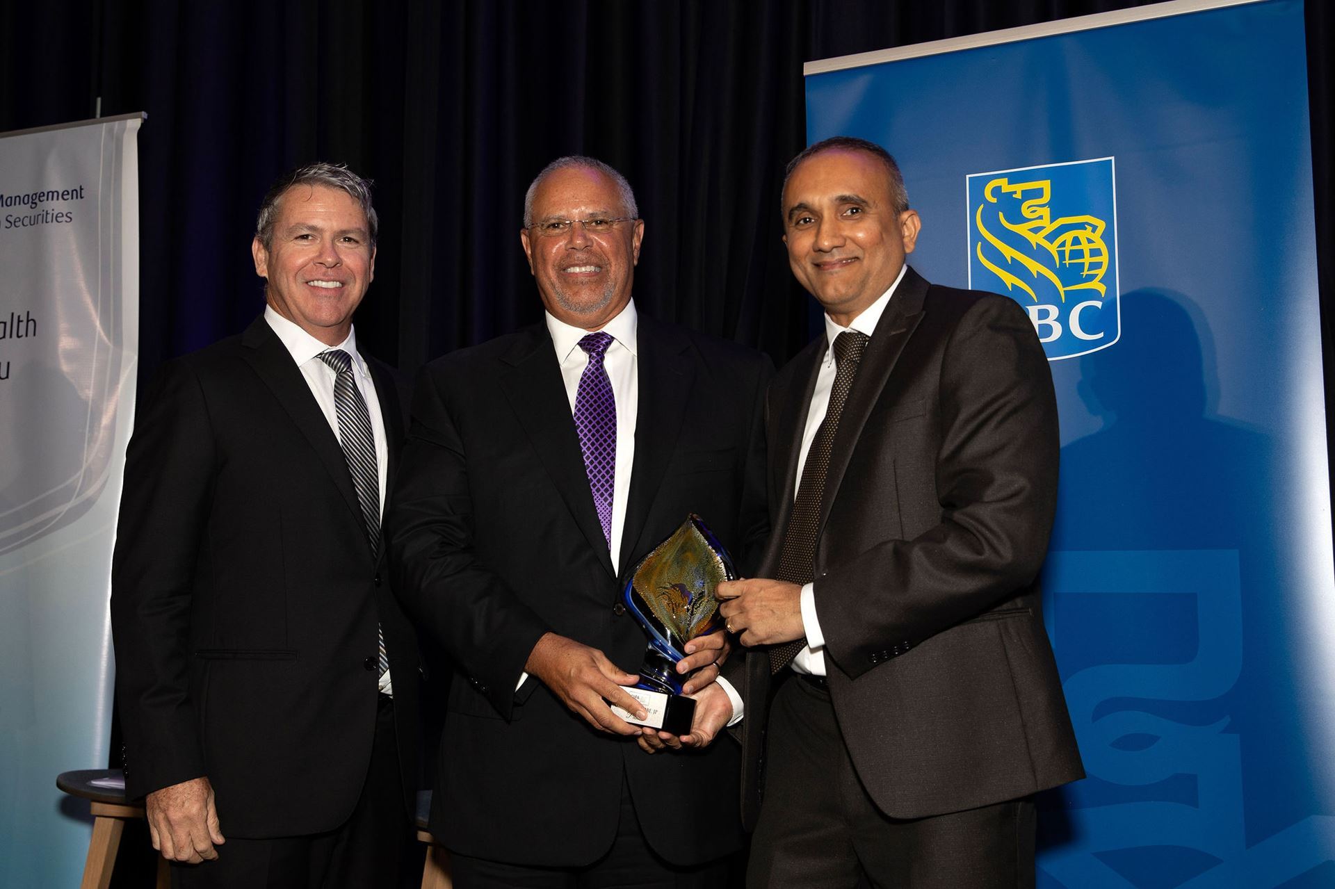 CIIPA President Rennie Khan, right, and Managing Director of RBC Wealth Management Andrew McCartney, left, present the Pioneer Award to recipient Layman Daniel “Dan” Scott during the 15th-annual CIIPA Awards Gala Saturday night (30 Sept.) at the Kimpton Seafire Resort + Spa.